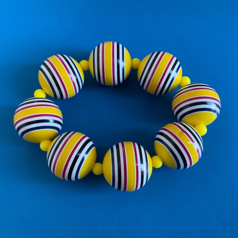 Vtg yellow bubblegum bead bracelet with black, white, and maroon stripes.